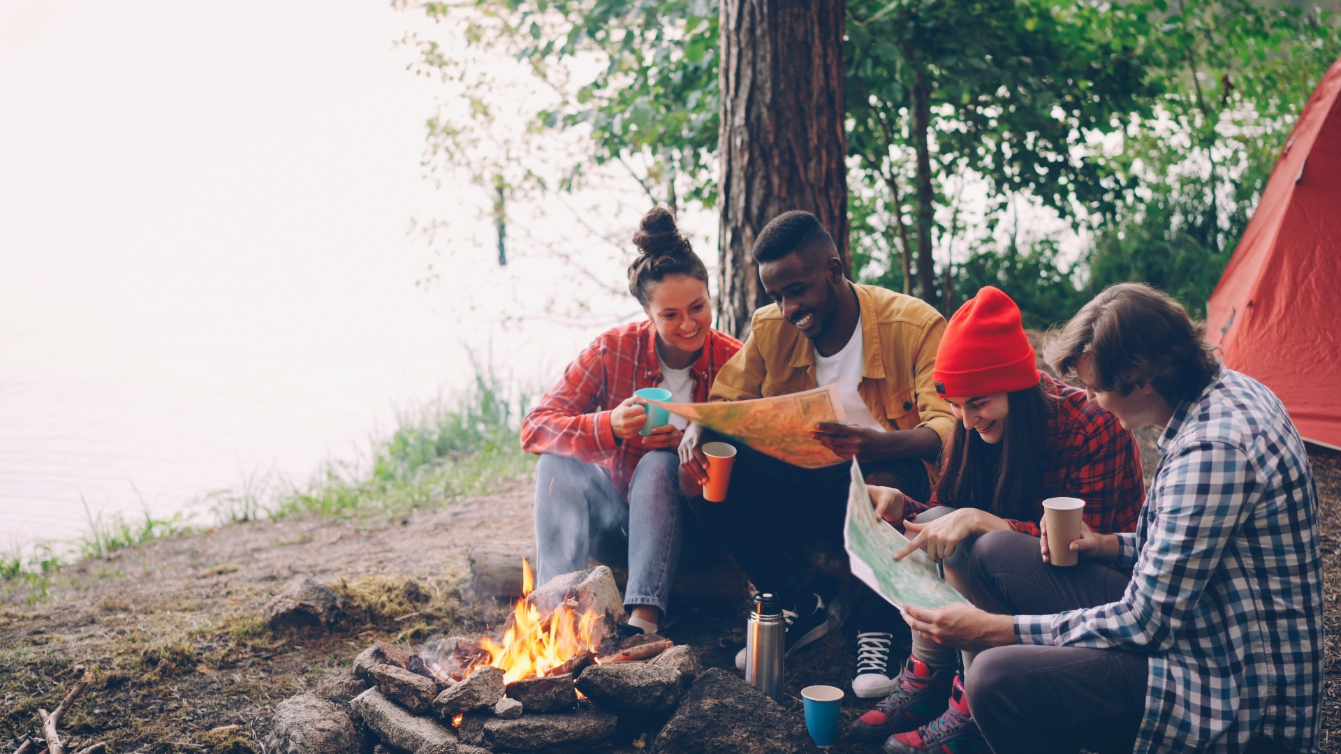 Friends planning a trip together around a campfire