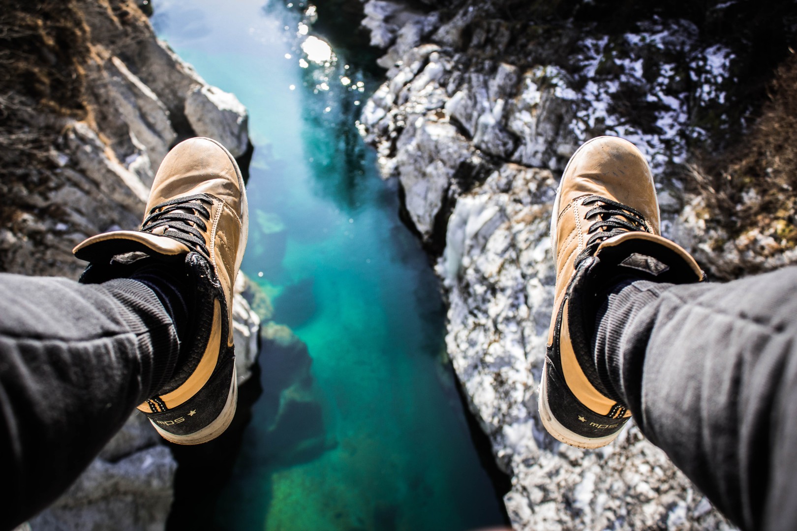 First-person view looking down into a turquoise canyon